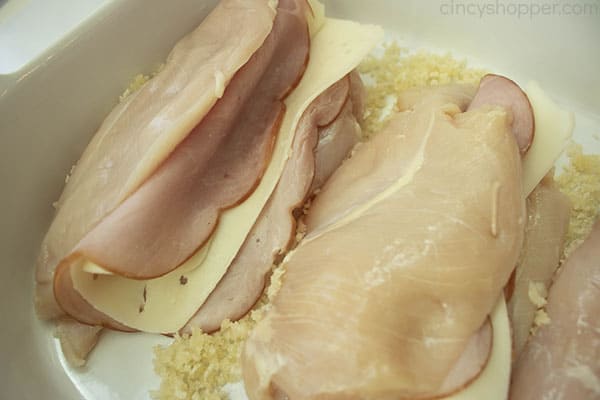 slices of ham and cheese inside butterflied chicken breasts
