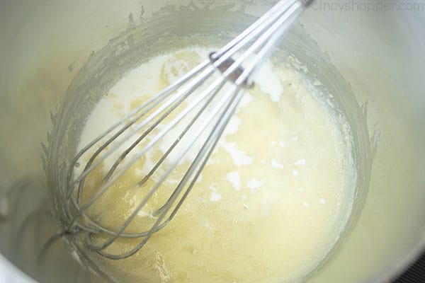 milk being whisked into a roux