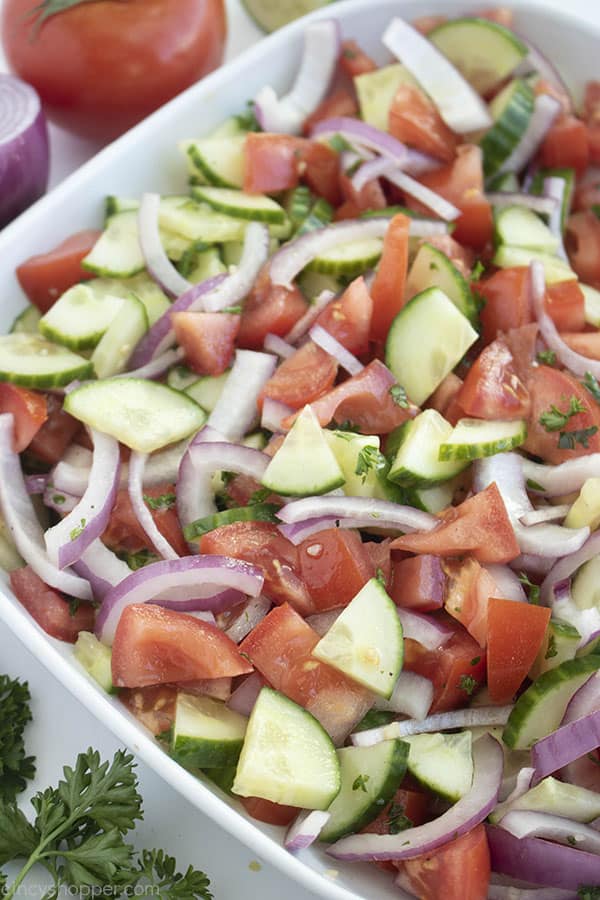 cucumber tomato onion salad in a white bowl