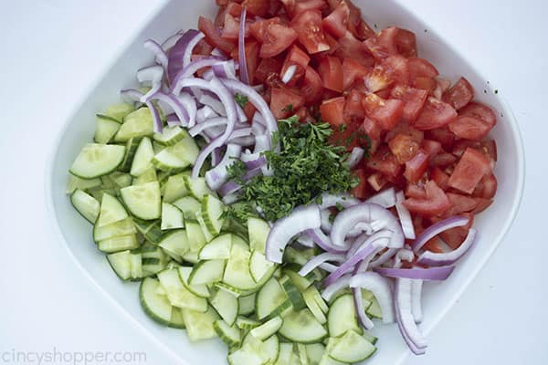 bowl of chopped cucumbers tomatoes and onions with fresh parsley