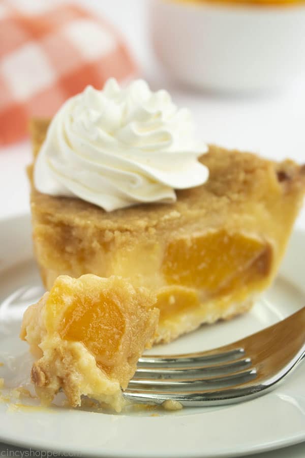 Fork with peach pie custard filling on a white plate