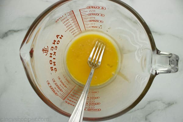 Large measuring cup with egg yolks and a fork