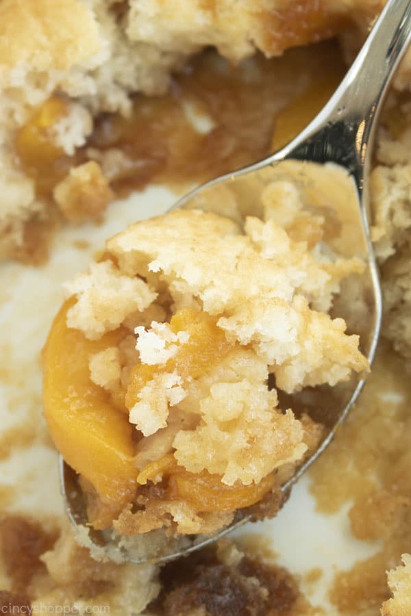 Spoon with crumbly peach cobbler