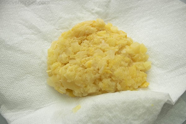 Crushed pineapple drained on a white paper towel.