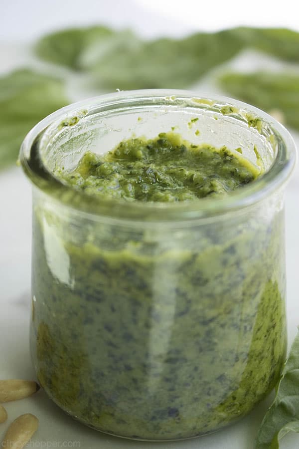 close up of green pesto in a glass jar