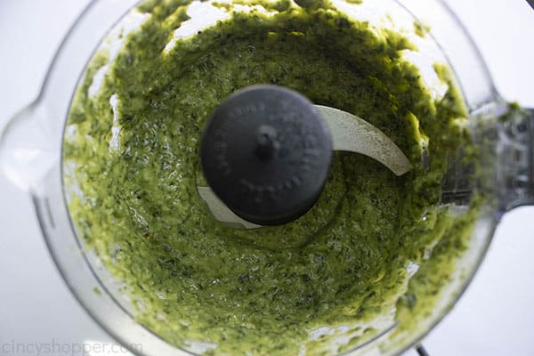 overhead photo of blended pesto in a food processor