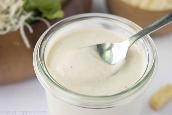 Homemade Caesar Dressing in a clear jar with a spoon