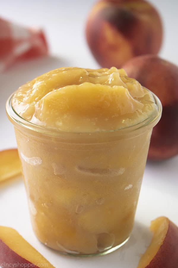 Homemade Peach Pie Filling in a clear jar on a white background