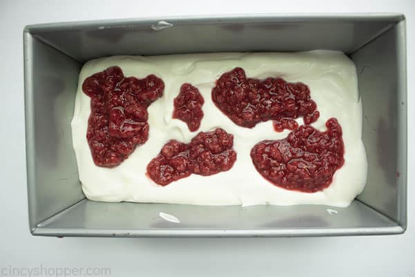 Raspberry topping on ice cream mixture in loaf pan