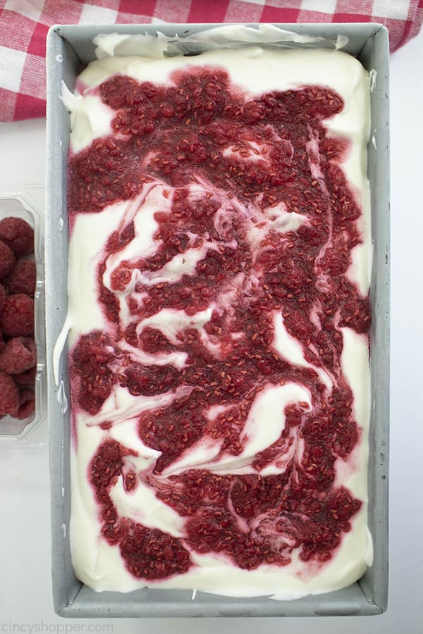 Raspberry swirled cheesecake ice cream in a metal loaf pan