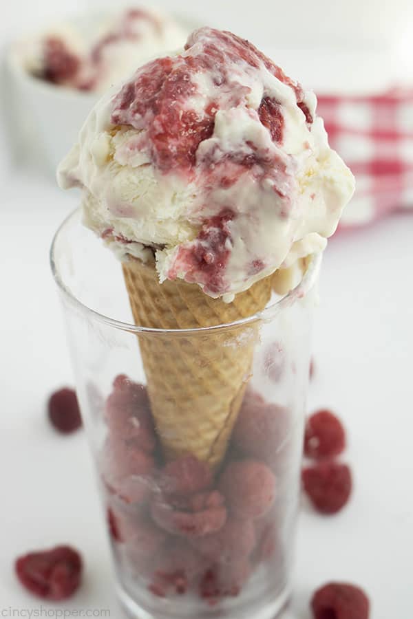 Ice cream cone with raspberry cheesecake ice cream in a clear glass
