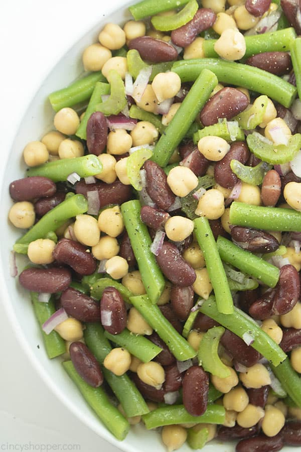 White bowl with a variety of beans, onions, celery, and spices