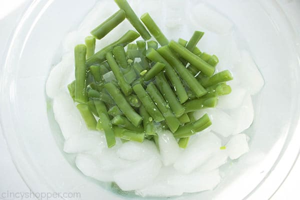 Cut green beans in a bowl with water and ice