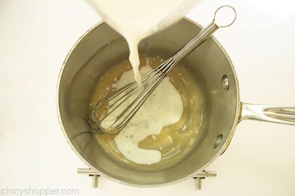 Overhead shot of the Cheese Mixture in a medium saucepan with the wet ingredients being poured in 