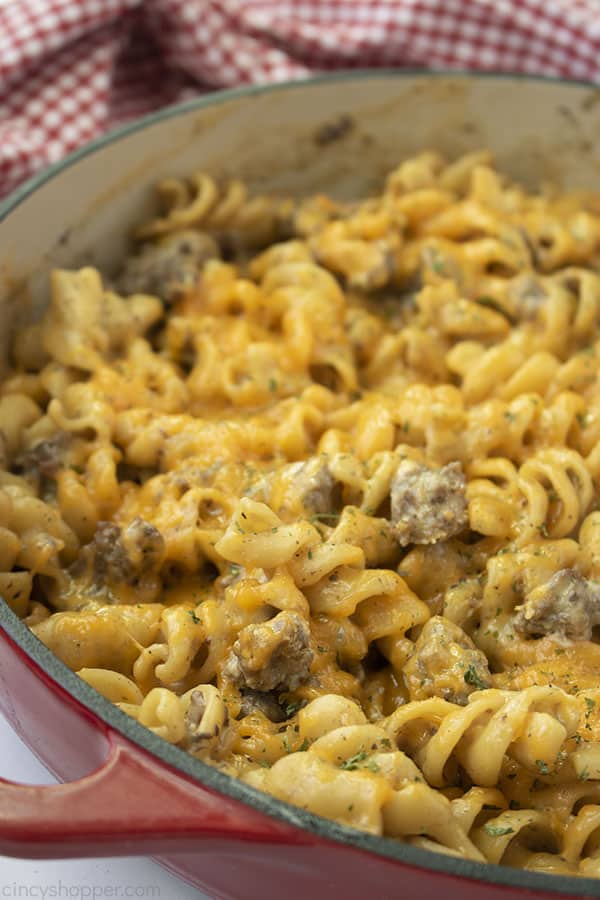 Close up shot of the Macaroni Hamburger Helper in a large red cast iron skillet with a red and white towel in the background 