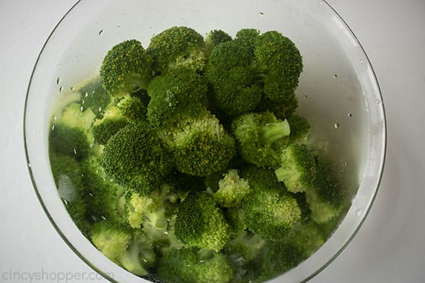 Blanched broccoli in a clear bowl with water