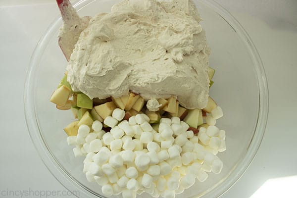 Overhead shot of all the ingredients being mixed into a large clear bowl with a red spatula 