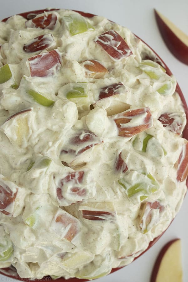 Up close shot of Creamy Apple Salad in a large red bowl with a white background