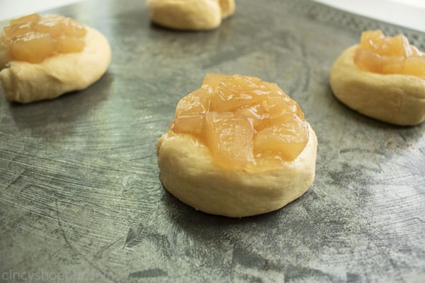 Danishes with apple topping on a silver baking sheet