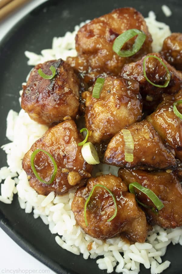 General Tso's Chicken over rice on a black plate.