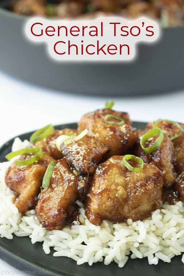 General Tso's Chicken on a black plate with text on image.