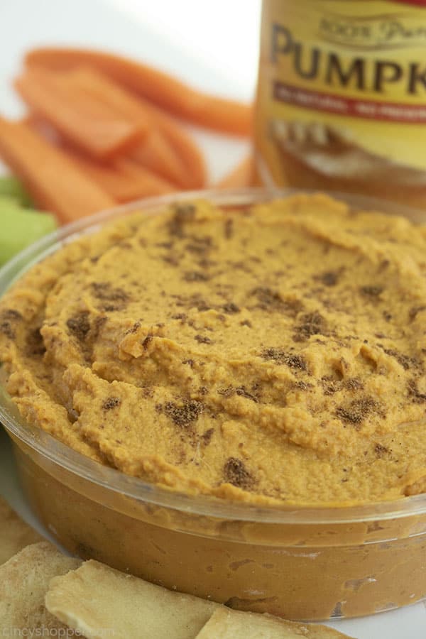 Savory Pumpkin Hummus in a clear dish with carrots, celery, pita chips and canned pumpkin.