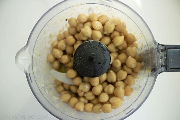 Garbanzo beans and olive oil added to food processor