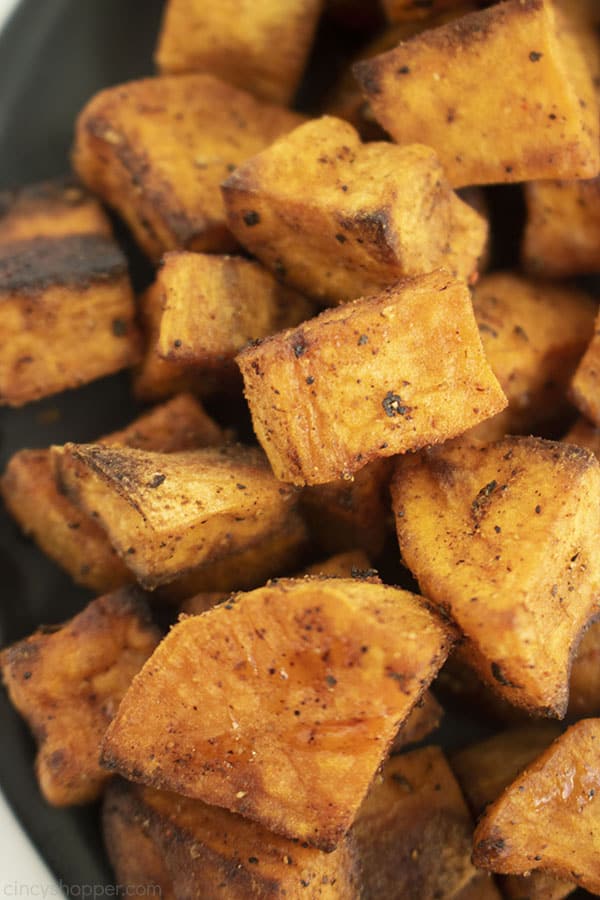 Roasted Sweet Potatoes on a black plate.