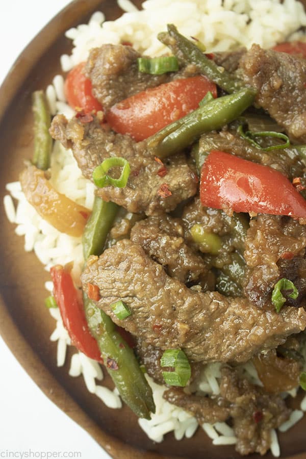 Plated close up picture of the Mongolian Beef on a brown wooden plate with white rice 