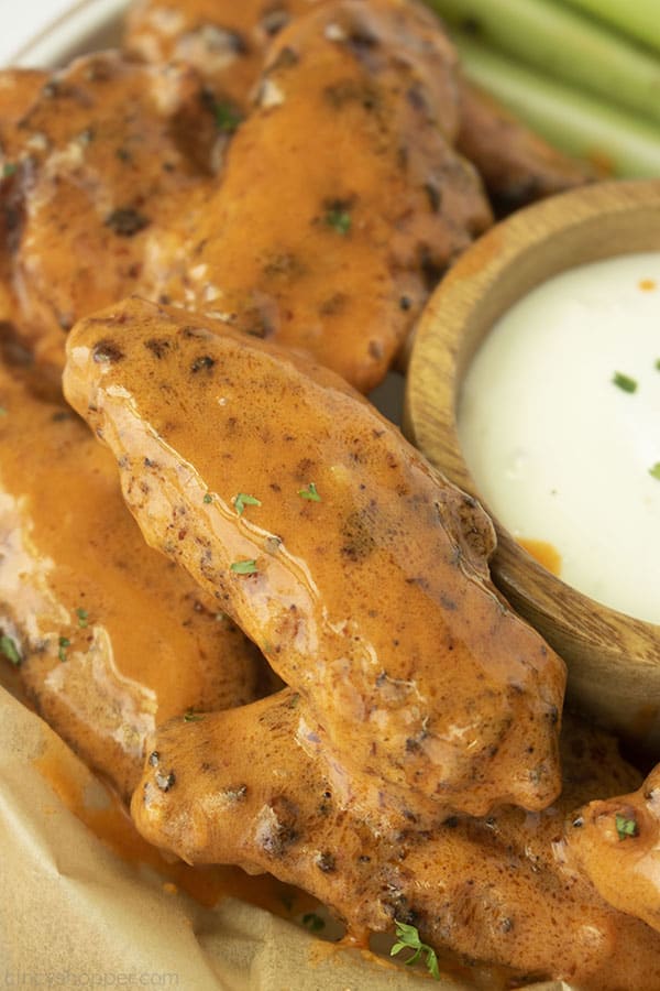 Sauced air fryer chicken wings with celery and blue cheese in background