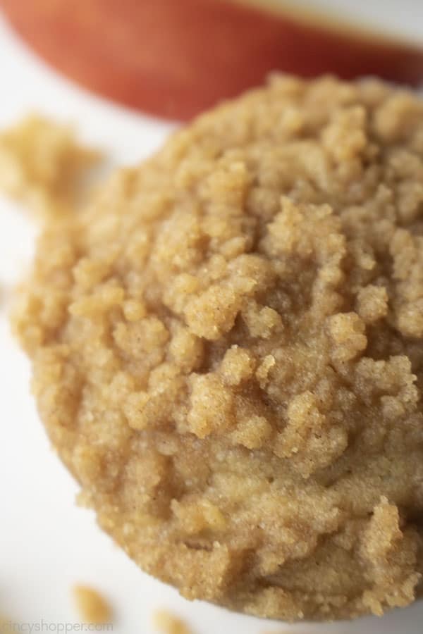 Overhead closeup of apple muffins with crumbs and apple slice