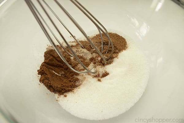 Cinnamon mixture in a clear bowl with a whisk 