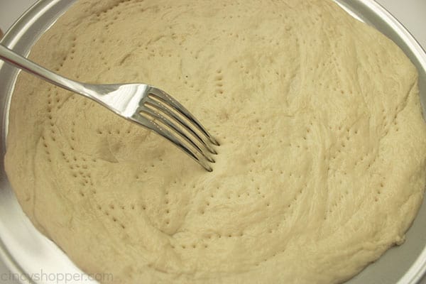 Fork docking prepared pizza crust