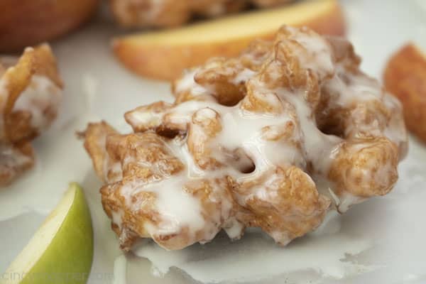 horizontal image of apple fritter with glaze and apple slices