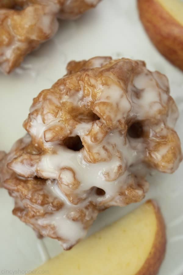 Tight overhead shot of apple fritter with glaze with an apple slice