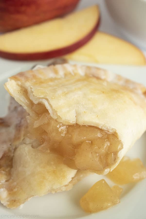 Opened apple pie with filling showing apple slices in background