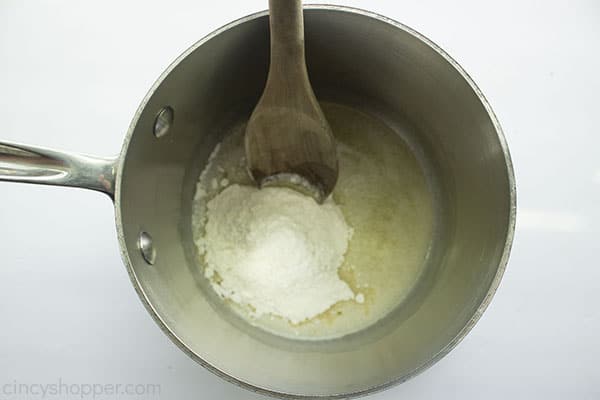 Flour added to melted butter with wooden spoon.