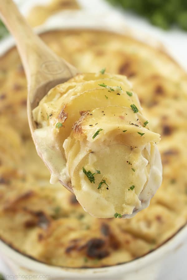 Au Gratin Potatoes on a raised wooden soon.