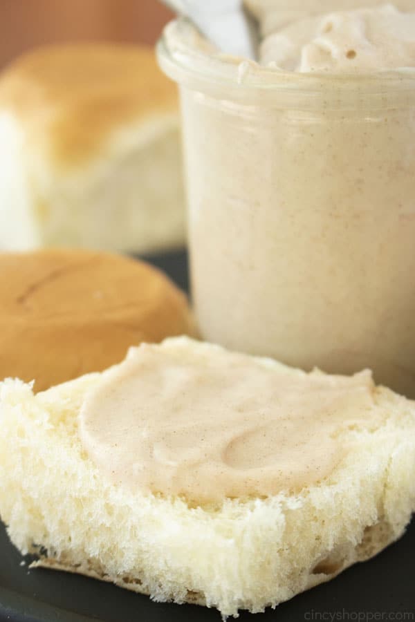 Cinnamon Butter spread on a roll. Jar and rolls in the background