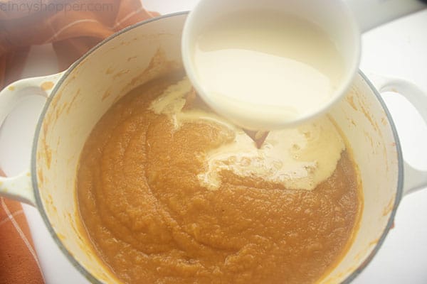 Evaporated milk added to soup in pan