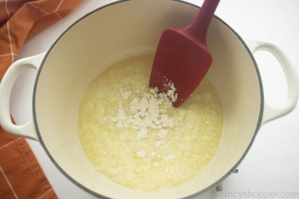 Flour added to onion mixture with a red spatula