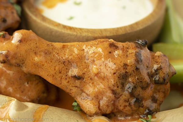 Wing with hot sauce with blue cheese dressing and celery in background