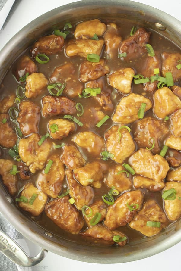 Orange Chicken in a stainless pan with a white background