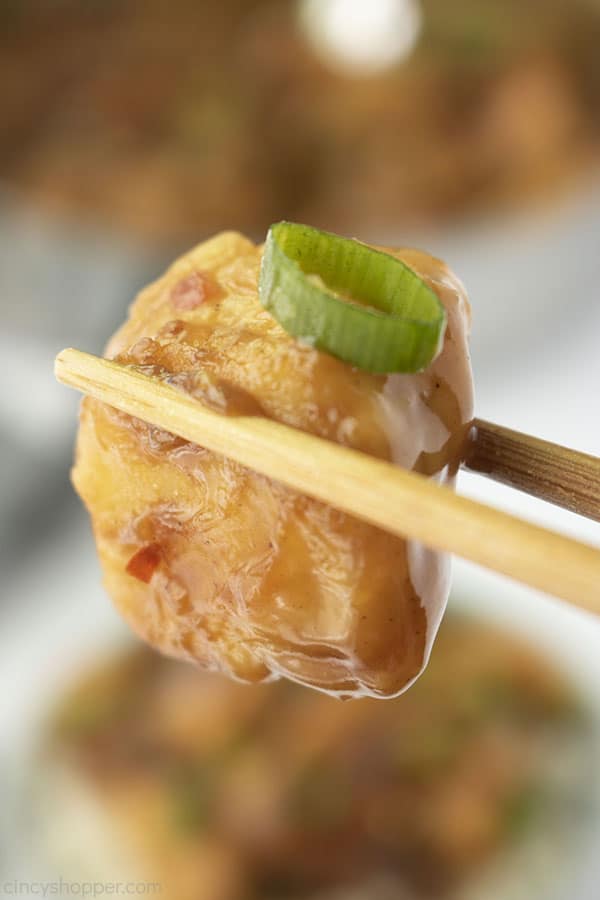 Chicken closeup between chopsticks. 