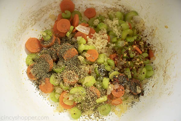 Spices added to vegetables in a white pot