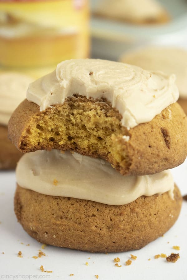 Stack of pumpkin cookies with one bite taken out of the top one