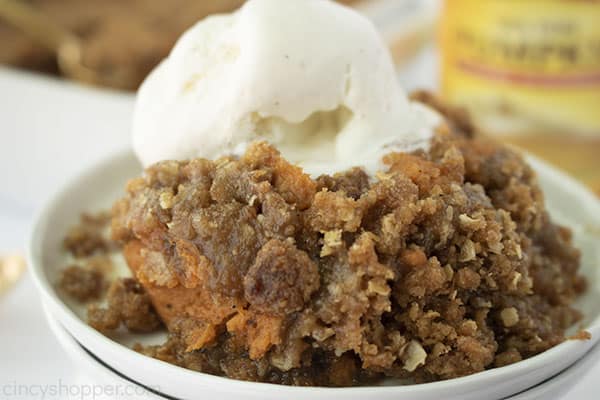 Horizontal shot of pumpkin crisp on a white plate with melting vanilla ice cream