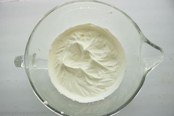 Whipped cream in a clear mixing bowl