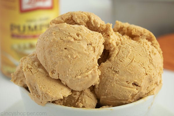 Scoops of no churn pumpkin ice cream in a white bowl with pumpkin can in background