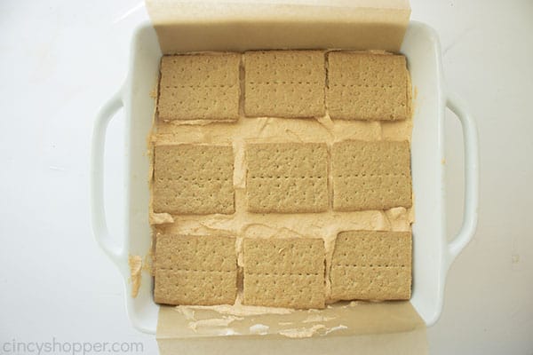 Overhead image of the second layer of graham layer being added to the top in a square white pan